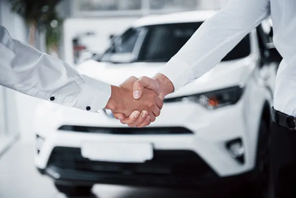 dos personas estrechándose la mano al completar su leasing de forma exitosa en un plazo igual o mayor a 12 meses